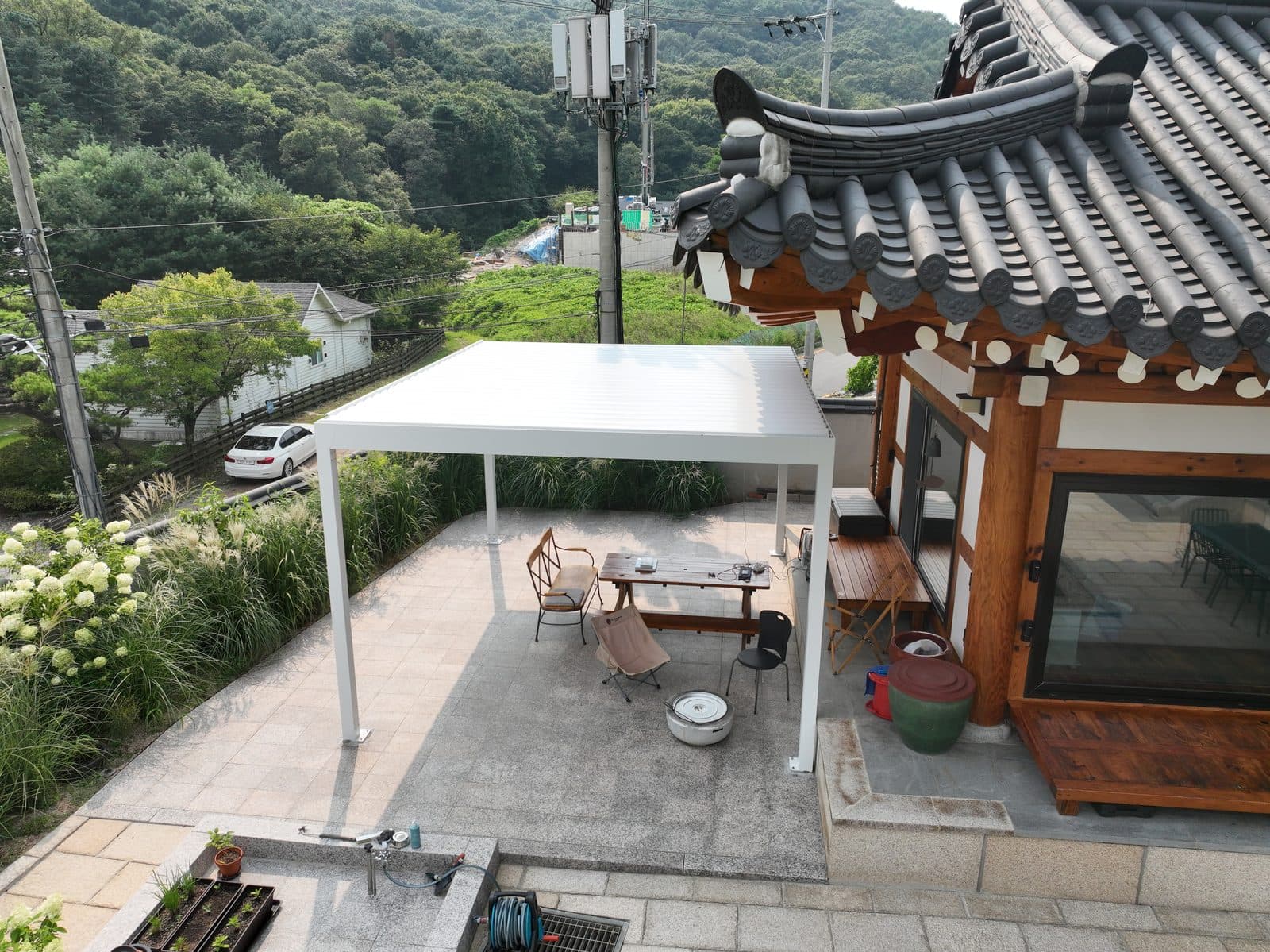 분당 한옥 마당 석재 바닥 위 화이트 파고라와 야외 테이블