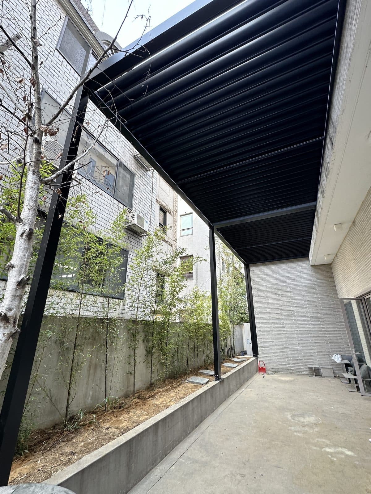 서울 강남구 건물 외부 공간 검은색 루버 파고라를 아래에서 본 모습
