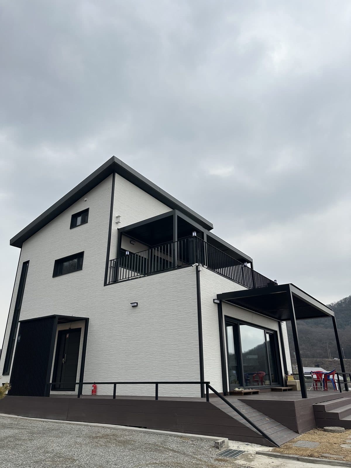 용인 2층 주택 측면에서 본 검은색 파고라 데크
