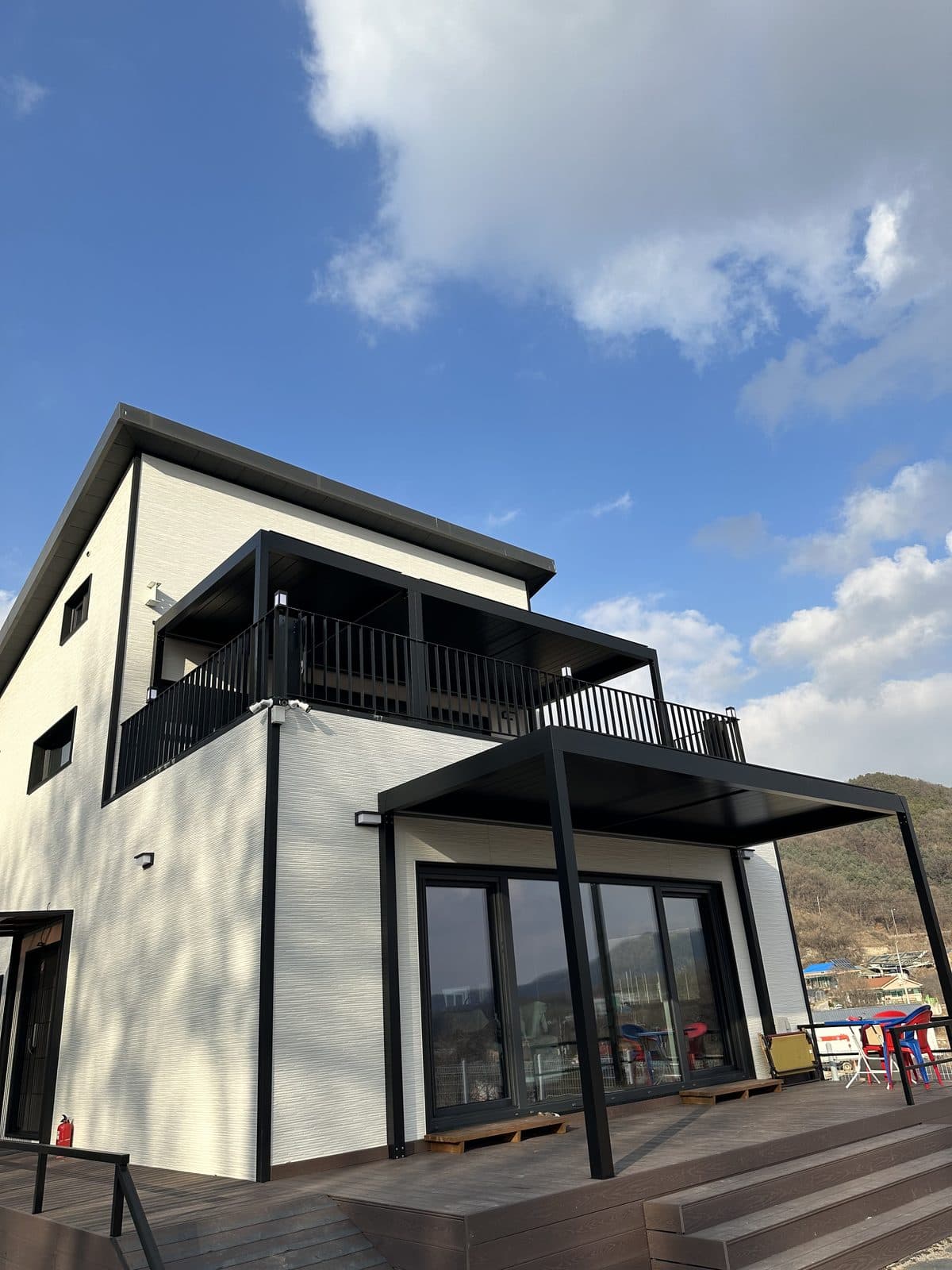 용인 2층 주택과 1층 데크의 검은색 루버 파고라